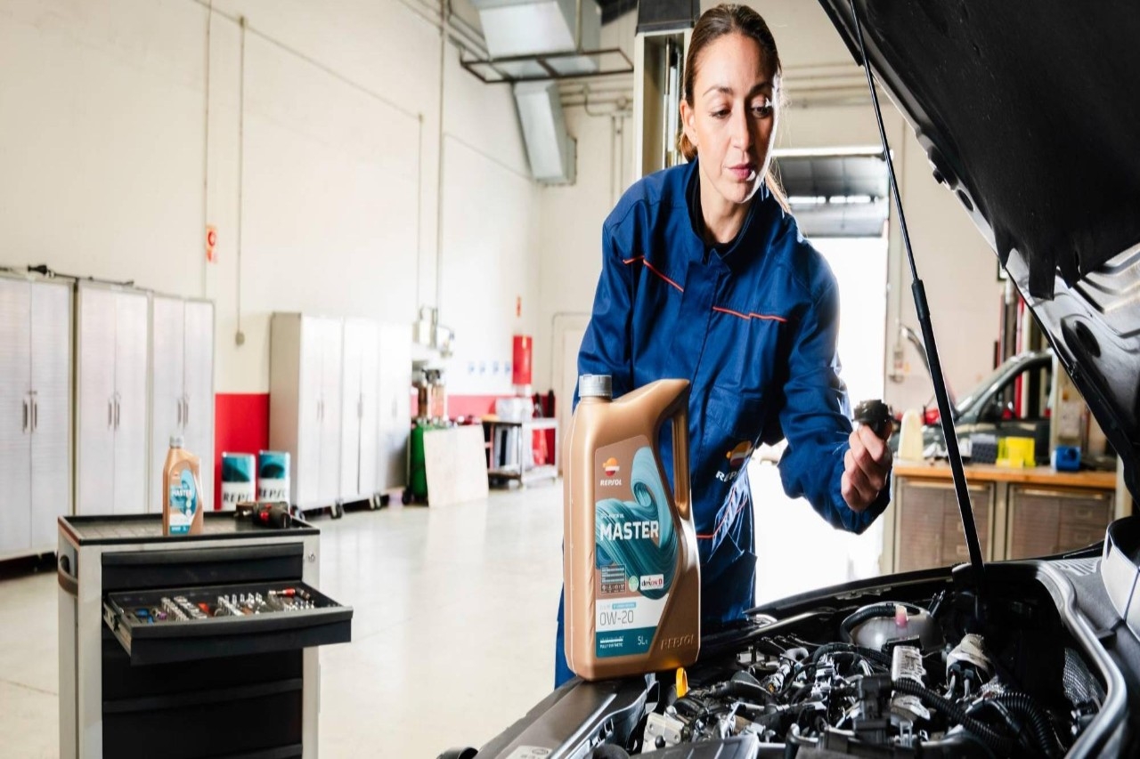 Mujer cambiando el aceite de un coche